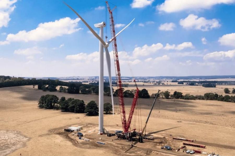 Heavy crawler crane installing wind turbine in renewable energy wind farm site
