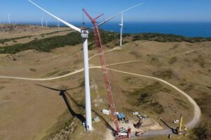 Crawler crane lifting wind turbine components in wind farm construction project