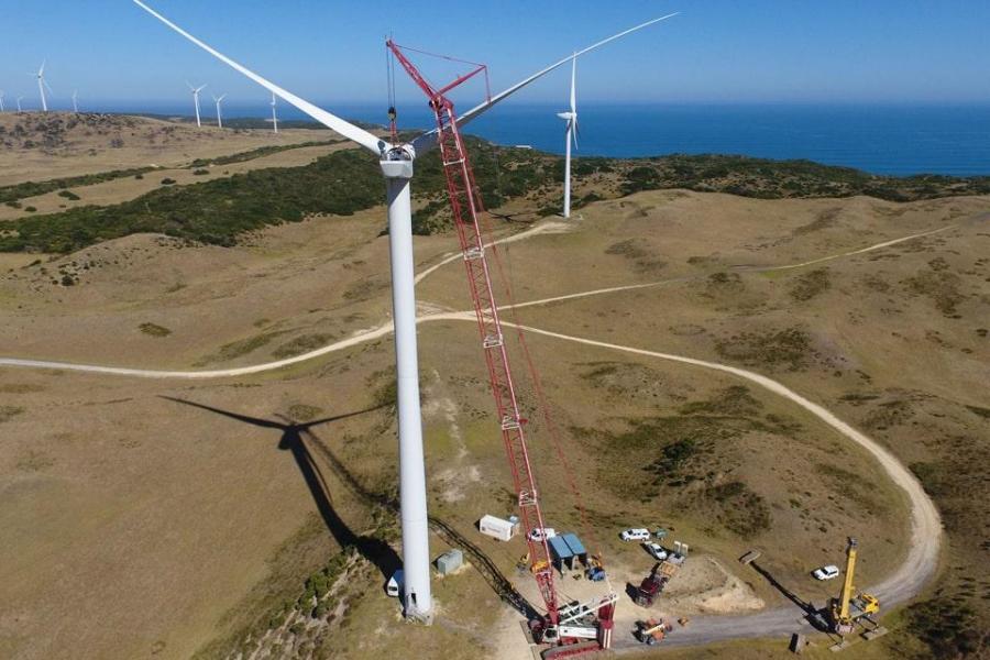 Crawler crane lifting wind turbine components in wind farm construction project