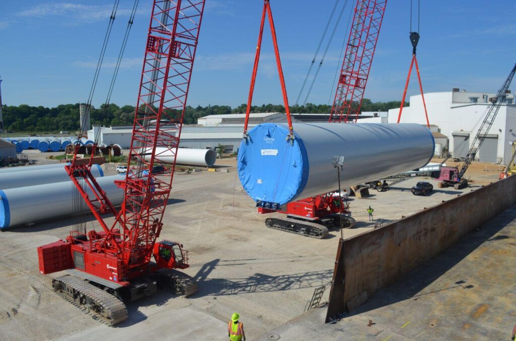 Two crawler cranes performing tandem lifting of wind turbine blade during installation