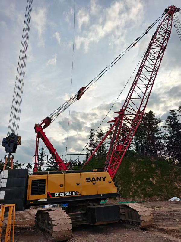 Lattice boom crawler crane lifting heavy construction materials